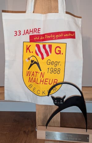 Foto einer Umhängetasche und einer Figur des Katers Rumskedi